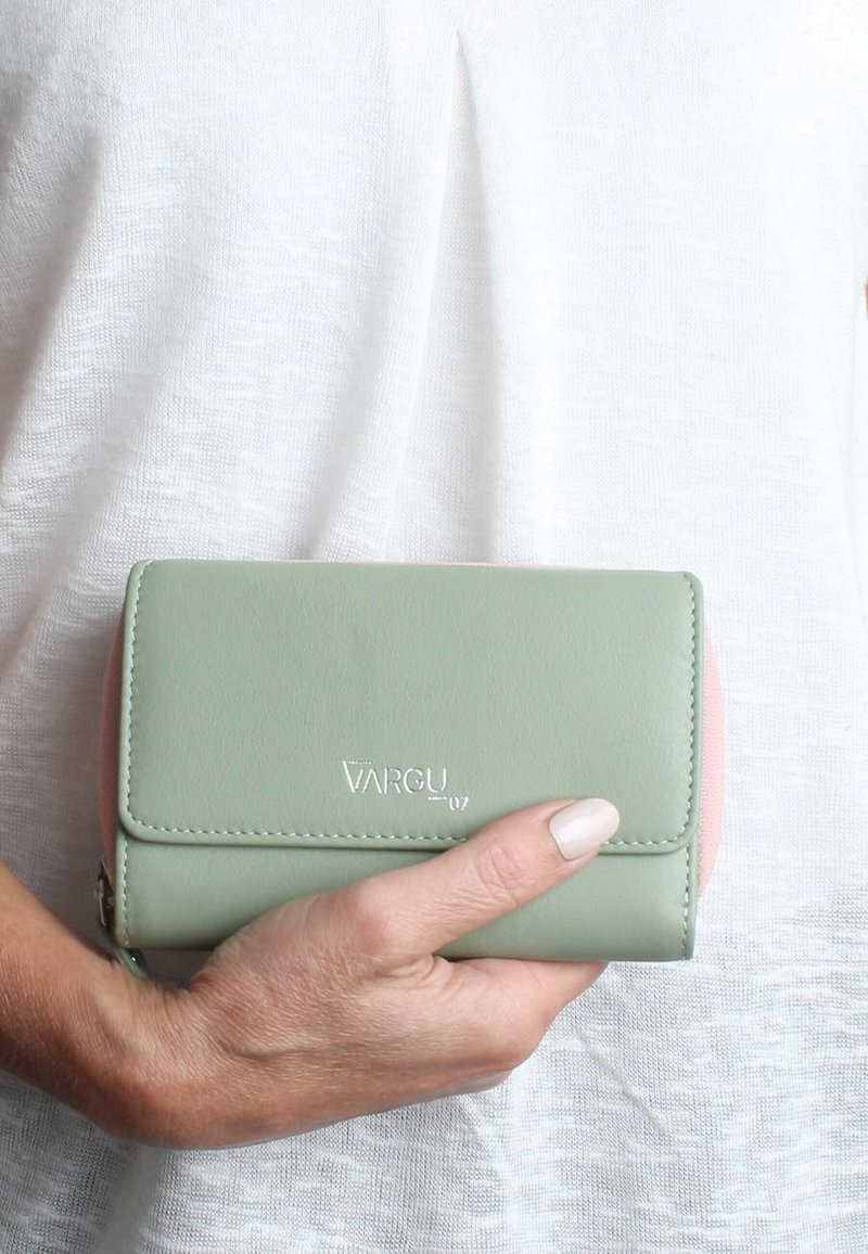 Grön och rosa plånbok av slät läder, med lockstängning, stickade kanter och präglad "VARGU 07"-logotyp. Kompakt design.