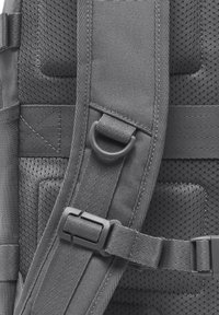 Rucsac gri cu țesătură texturată, secțiuni din plasă căptușite, bretele reglabile și o cataramă din plastic pentru închidere sigură.