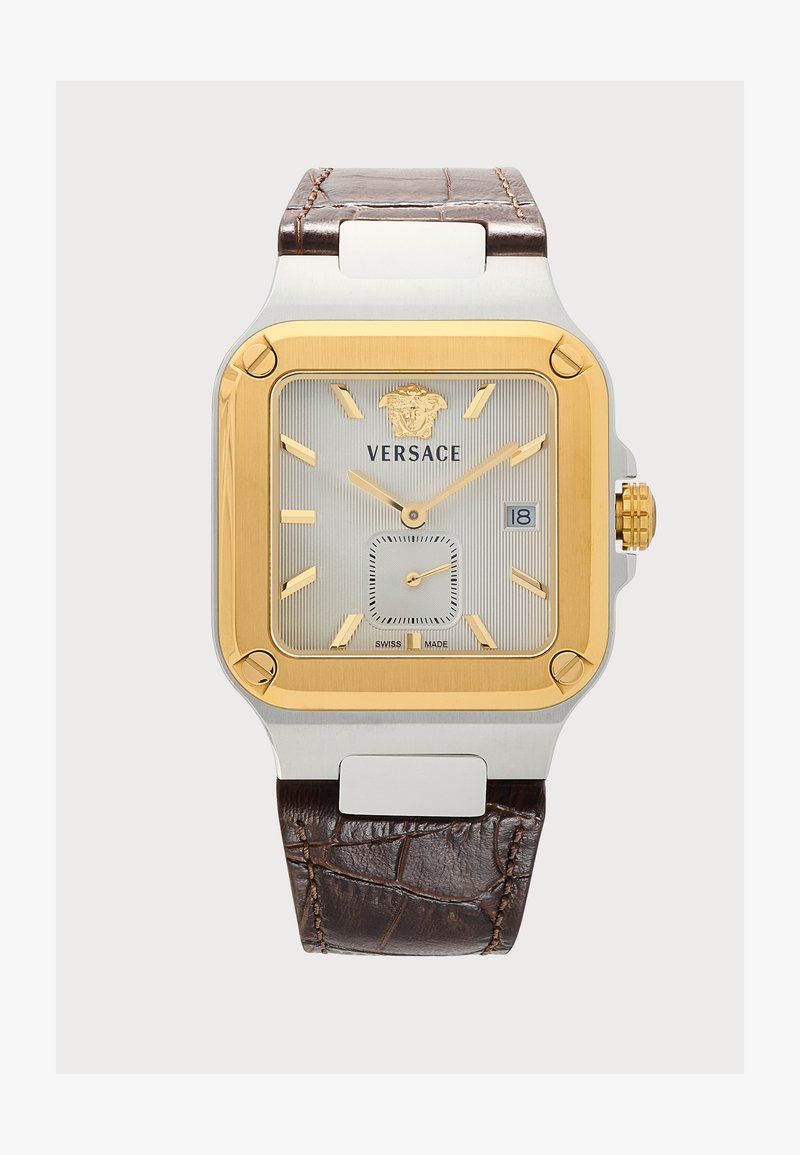 Montre-bracelet carrée Versace avec lunette dorée, cadran argenté, index dorés, guichet date et bracelet en cuir marron texturé.