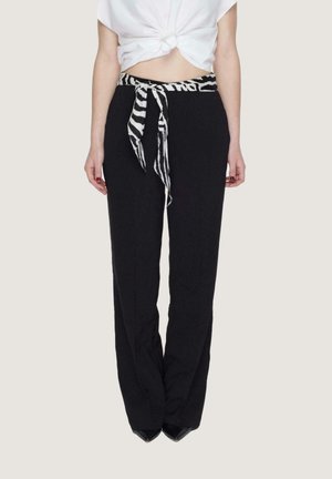 Pantaloni neri con vita aderente e gambe ampie, accentuati da una cintura a strisce zebrate bianca e nera legata. Tessuto liscio con una leggera lucentezza.