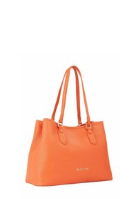Sac tote en cuir orange avec texture lisse, deux longues poignées et quincaillerie argentée. Affiche le logo de la marque sur le devant.