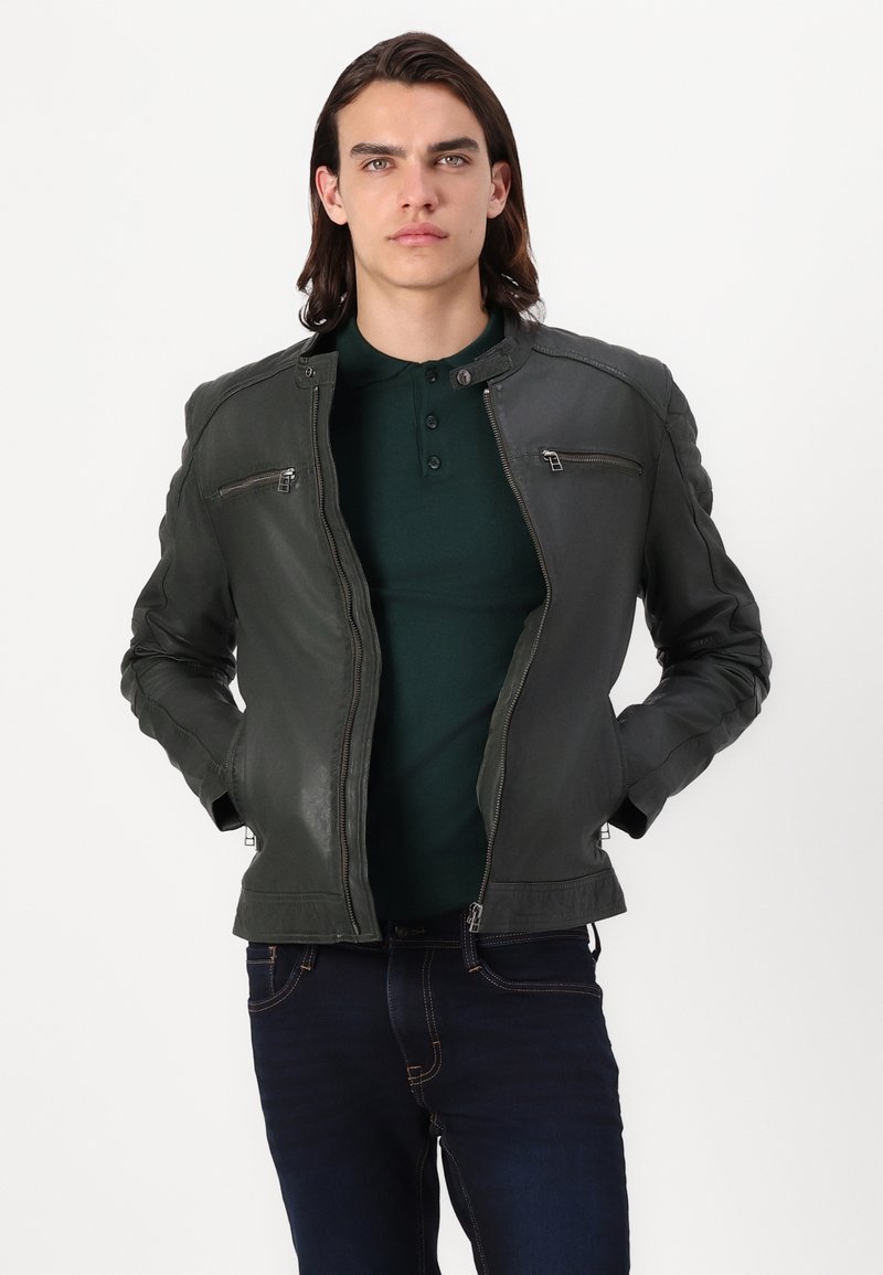 Veste de moto en cuir vert foncé avec un design ajusté, un col montant, des poches zippées et des accents texturés aux épaules.