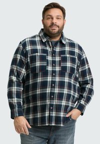 Blauwe en groene geruite flanellen shirt met twee borstzakken, knoopsluiting en een ontspannen pasvorm; voorzien van houten knopen en een zachte textuur.
