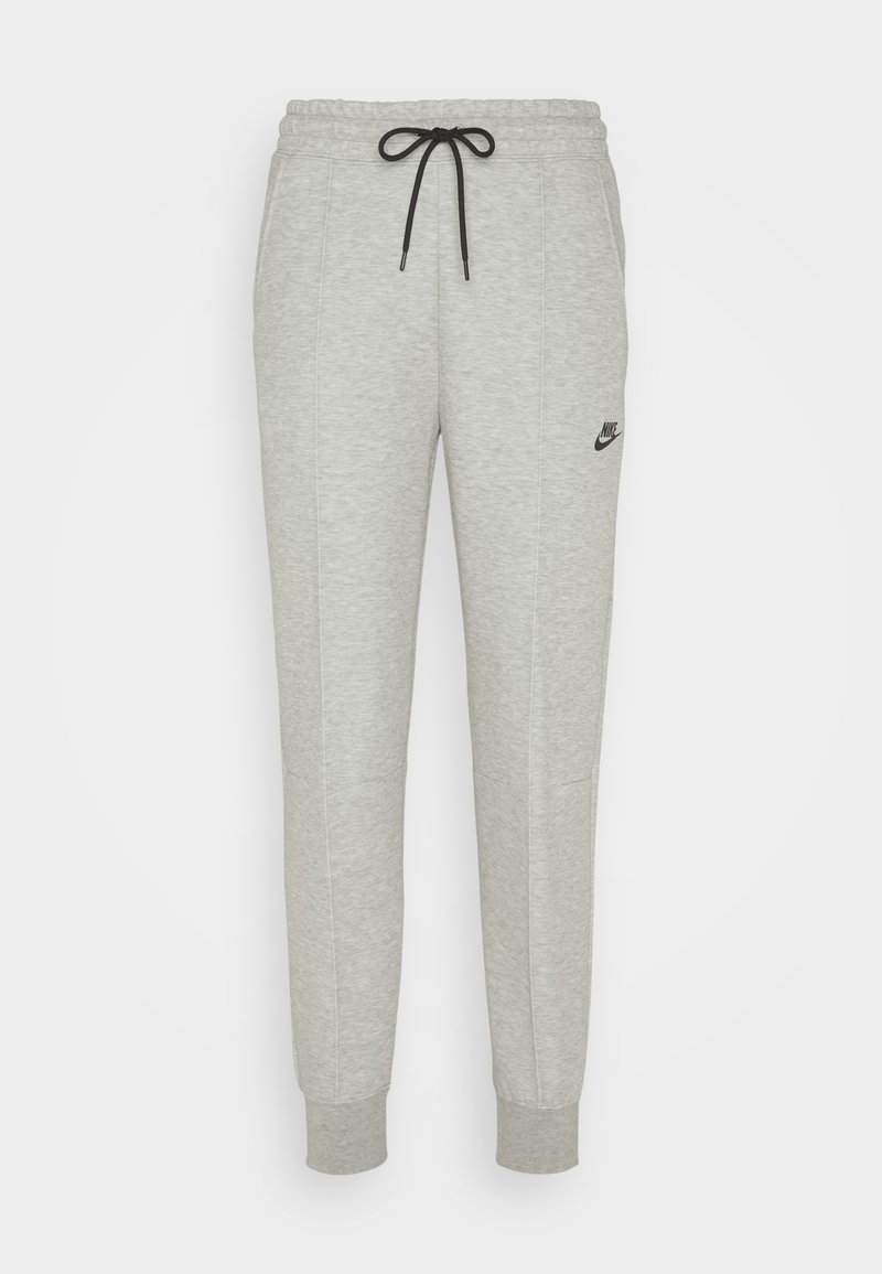 Pantalones de chándal grises hechos de un material suave, con una cintura elástica, cordón negro y un pequeño logo negro de Nike en el muslo izquierdo.