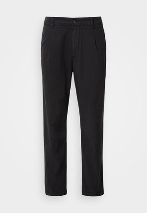 Zwarte broek van gladde stof met een rechte pijp, voorkruisen en een knoopsluiting bij de taille.