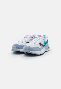 Scarpe da ginnastica bianche e grigie con tomaia in rete, dettagli in camoscio, elementi rosa e teal, e suola stratificata con ammortizzazione Air visibile.