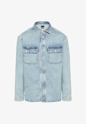 Camicia in denim azzurro chiaro con due tasche sul petto, davanti con bottoni e colletto tradizionale. Presenta una texture scolorita e maniche lunghe.