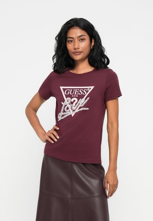 T-shirt en coton bordeaux avec un col rond, des manches courtes et un logo triangulaire "GUESS" en crème et argent en embellissement.