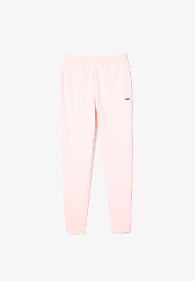 Calças de treino rosas feitas de um tecido suave, com um cós elástico e punhos, apresentando um pequeno logo verde da Lacoste na perna esquerda.