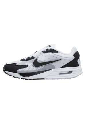 Nike sneaker in black and white with a mesh upper, suede accents, and a visible air cushioning unit in the sole. Features a swoosh logo.