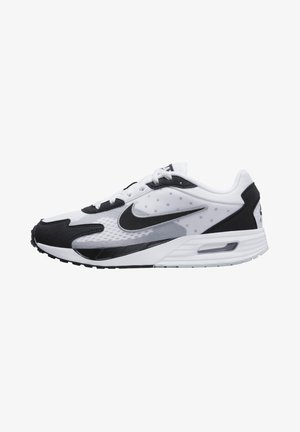 Zapatilla Nike en blanco y negro con parte superior de malla, acentos de ante y una unidad de amortiguación de aire visible en la suela. Presenta el logo de swoosh.