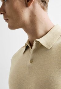 Beige polo shirt met korte mouwen van textuurstof, met een klassieke kraag, twee knopen en een getailleerd ontwerp voor een gestroomlijnde uitstraling.