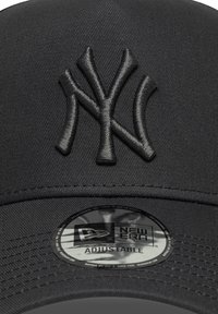 Juodas New Era kepurė su išsiuvinėtu NY logo, reguliuojama juosta ir glotniu paviršiumi, pasižymintis struktūrine forma.