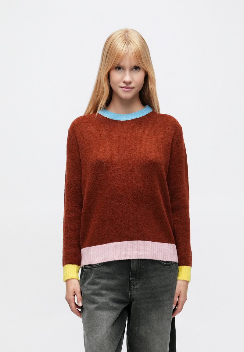 Maglione lavorato a maglia color ruggine con scollo tondo azzurro chiaro, orlo a coste rosa e dettagli gialli sulle maniche. Tessuto morbido e strutturato.