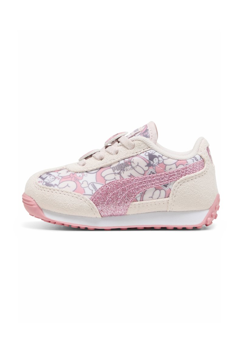 Zapatilla de deporte rosa claro con un patrón floral brillante, acentos de gamuza y un logo lateral rosa brillante; suela de goma con un texturizado para mayor agarre.