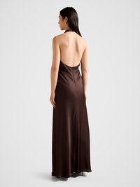 Robe en satin marron �à col halter, dos nu, silhouette fluide, longueur jusqu'à la cheville, présente un léger éclat et une fermeture éclair au dos.