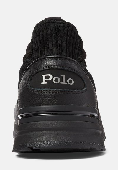 Svarta sneakers med en texturerad stickad ovandel och en slät läderhæl. Har en grå "Polo"-logotyp, dämpad sula och glänsande detaljer.