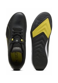 Mustat urheilukengät, joissa keltaisia ja valkoisia yksityiskohtia, sileä päällinen, rei'itetty muotoilu, nauhakiinnitys ja kuvioitu ulkopohja.