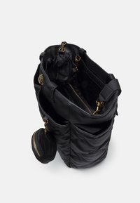 Svart quiltad tygväska med guldfärgad hårdvara, flera fack och en fastsatt rund påse med dragkedja.