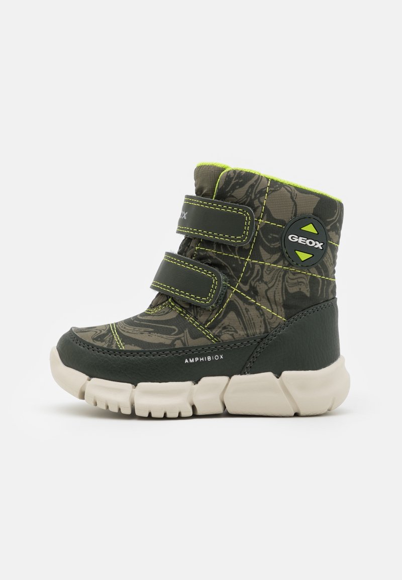 Botte d’hiver enfant verte et noire avec deux bandes velcro, motif camouflage, semelle blanche épaisse et logo Geox sur le côté.