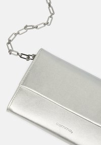 Portafoglio metallico argento con una superficie liscia, dotato di una tracolla a catena e del logo "virgola" in rilievo sul fronte. Design compatto e rettangolare.