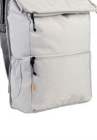 Grijze stoffen rugzak met een flap bovenkant, een voorvak met rits, een zijvak van gaas en het Bench-logo. Bevat zwarte ritsen en een gele accent.