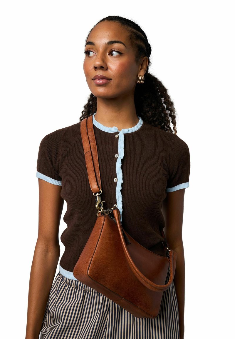 Hnědý žebrovaný krátký rukáv s světle modrým lemem a knoflíky, doplněný hnědou koženou kabelkou přes rameno s elegantním tvarem a ramenním popruhem.