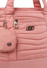 Bolso tote acolchado en rosa con bolsillo con cremallera y un estuche circular, acentuado con hardware en tono plateado y un detalle de logotipo.