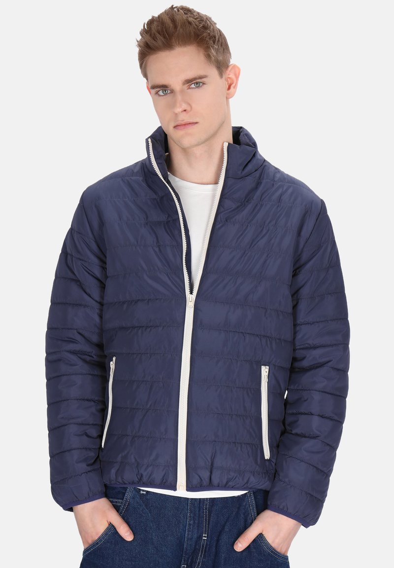 Marineblaue Pufferjacke mit horizontalen Nähten, hohem Kragen, weißem Reißverschluss und seitlichen Taschen. Leichtes Material und glatte Textur.