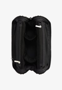 Bolsa organizadora negra con cremallera abierta que muestra dos compartimentos principales con bolsillos de malla con cremallera y divisores acolchados en el interior.