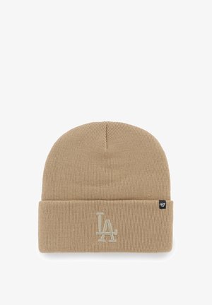 Beige knit beanie with a rolled cuff, featuring embroidered "LA" logo in light color and woven brand tag on the side.