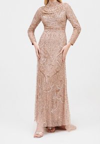 Perlede, langærmet kjole i blush pink med indviklede, snoede mønstre og en draperet halsudskæring. Gennemsigtigt stof med udsmykninger overalt.
