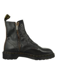 Svart läderankelboot med siddragkedja, rund tå, snörning fram med metallögon, och en strukturerad gummisula med gul sömnad.