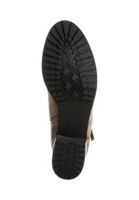 Hnědá semišová kotníková bota s černou gumovou podrážkou, která má texturovaný vzorek a boční zip. Bez viditelných švů nebo ozdob.