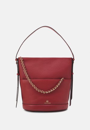 Rode leren bucketbag met gouden kettingdetail, enkele schouderriem en Michael Kors-logo aan de voorkant.