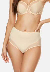 Nude, wysokie majtki z przeźroczystymi bocznymi panelami i gładką fakturą. Posiadają miękką gumkę w talii oraz subtelne detale przeszyć.