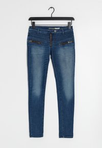 Jean skinny en denim dans un délavage bleu foncé. Il présente deux poches zippées à l'avant, une taille texturée et une fermeture éclair à l'avant.