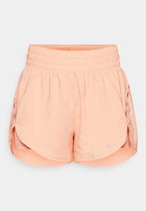 Calções de atletismo cor pêssego com uma cintura franzida, fendas laterais e um logo da Nike refletor no lado inferior esquerdo. Tecido leve.