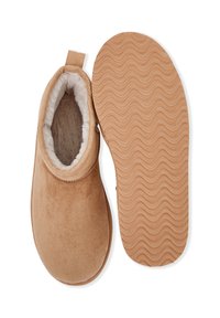 Pantofole scivolate in suede color beige con una morbida fodera in pile, dotate di una suola in gomma testa di moro con un motivo ondulato e un inserto per il tallone.