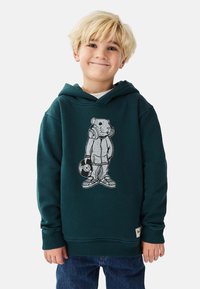 Mörkgrön hoodie med avslappnad passform, med en grafik av en björn som bär hörlurar och håller i en vinylskiva. Bomullsmaterial.