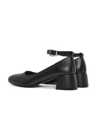 Zapatos de tacón de cuero negro con punta redonda, correa al tobillo y tacón cuadrado. Textura suave con un detalle mínimo y un diseño elegante.