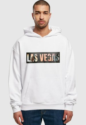 Hvid hættetrøje med en lomme foran og en iøjnefaldende "LAS VEGAS" grafik i et sort rektangel. Stoffet ser blødt ud med en afslappet pasform.