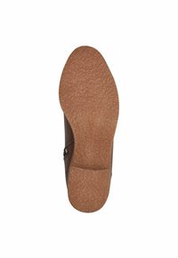 Suola di scarpa marrone con superficie texturizzata, punta arrotondata e zip laterale. Tallone rinforzato con una finitura liscia.