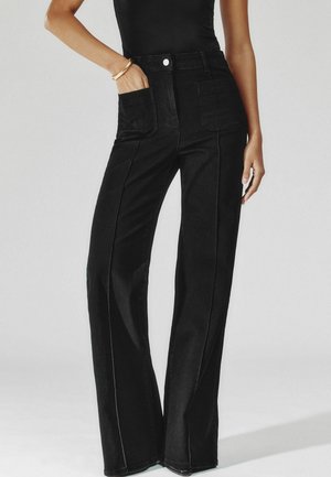 SAKURA PATCH POCKET - Flared jeans - black