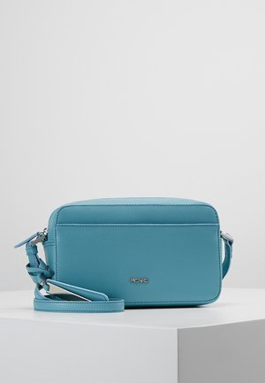 Rektangulær blå læder crossbody-taske med justerbar rem og sølvlynlås, placeret på en hvid overflade mod en lysegrå baggrund.