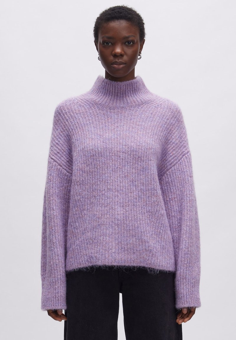 Lavendel gestrickter Pullover mit hohem, geripptem Kragen, gesenkten Schultern und lässigem Schnitt. Weiche Textur mit leicht flauschiger Oberfläche.