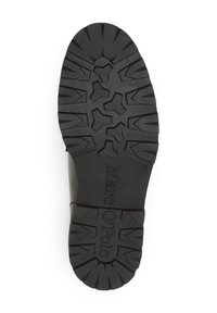 Suela de goma negra con un patrón de agarre texturizado, que incluye un logo central y una marca de tamaño. Diseñada para ofrecer tracción y durabilidad.
