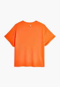 Kortærmet t-shirt med rund hals i lys orange stof. Glat tekstur med en lille logo detalje på ryggen nær halsen.