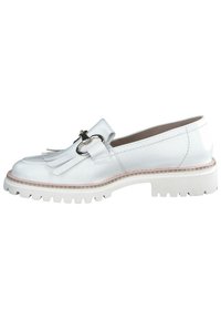 Witte leren loafers met een franjerand, zilveren hardware details en een dikke witte rubberen zool met een gestructureerd patroon.