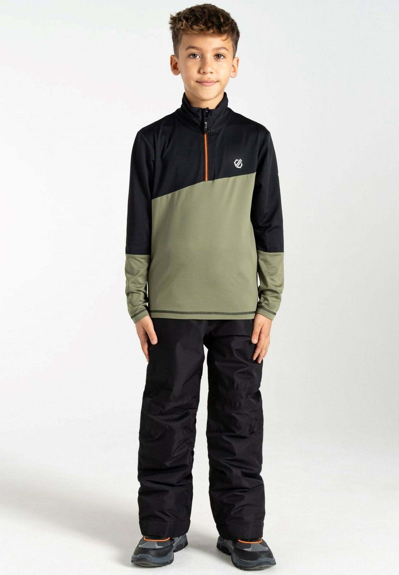 Grüne und schwarze Zip-Jacke mit orangefarbenem Reißverschluss, langen Ärmeln und Logo. Kombiniert mit schwarzen Hosen und grauen Schuhen. Glatte Stofftextur.
